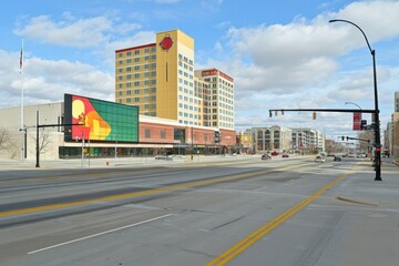 Obraz premium Urban scene featuring a large building with colorful signage and a clear blue sky.