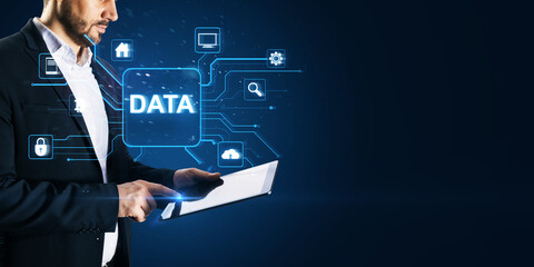 Headless young man using tablet with glowing data hologram on blue background with mock up place. Big data, Application programming interface concept.