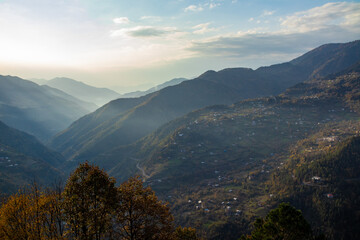 Fototapeta premium A stunning view of a valley surrounded by tall mountains and trees