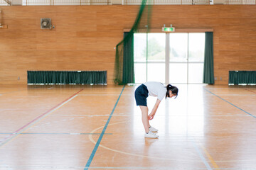 Obraz premium 体育館でストレッチをする女の子