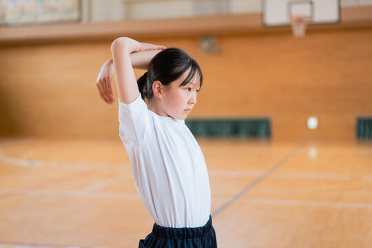 体育館でストレッチをする女の子