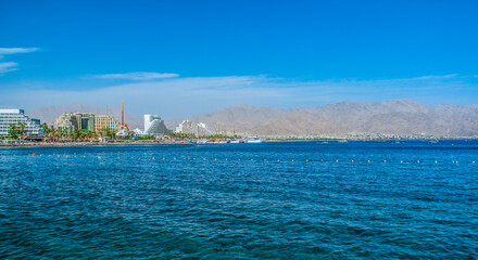 sea scape resort hotels luxury reach district waterfront UAE country panorama landscape with water foreground and desert mountains background summer travel destination view