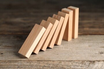 Domino effect. Wooden blocks falling on table, closeup