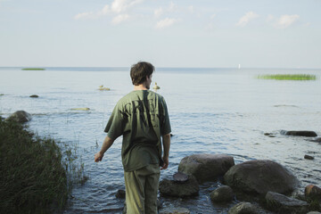 Man standing back and looking at the sea.