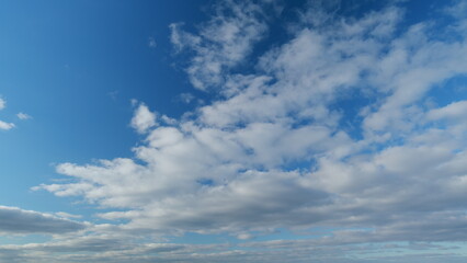 Obraz premium Blue sky with beautiful stratocumulus clouds. Beautiful sunny blue sky background with clouds. Timelapse.
