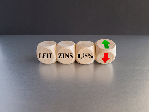 Cubes form the German expression Leitzins 0.25 percent (key interest rate 0.25 percent). Symbol for the increase or decrease of the key interest rate by the European central bank. Black background.