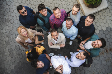 Top view photo of a group of business people and colleagues standing together holding hands,...