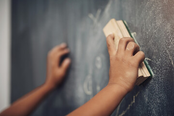 Child, hands and student with duster on chalkboard for erase, redo or learning at school. Closeup,...