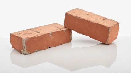 Two red bricks resting on a white surface