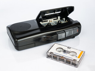 Audio micro cassette recorder and micro cassette tape in foreground, isolated