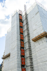 Large Building Restoration Surrounded By Scaffolding And Sheeting