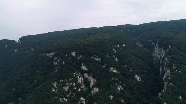 Aerial drone view of Dengfeng color Cableway near Shaolin temple in China. Cable cars run through forest near the Pagoda Forest and Shaolin Temple. Songshan Mountain in Dengfeng City, Henan Province.