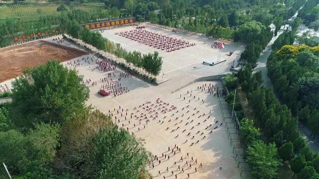 Aerial drone view of Shaolin temple training Martial arts in China. Training Pupils Martial Arts School on the Square. Students practice martial art in Shaolin Temple in Dengfeng city, Henan.