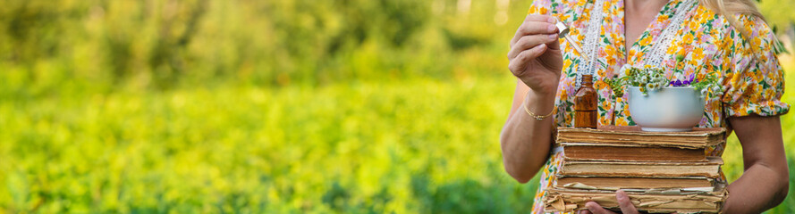 Woman with medicinal herbs in a meadow. Selective focus.
