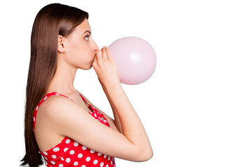 Profile side photo of astonished girl inflating balon looking wondering wearing polka dot dress singlet isolated over teal turquoise background © deagreez