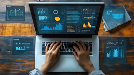 Hands typing on laptop with data analytics and financial graphs on screen and desk.
