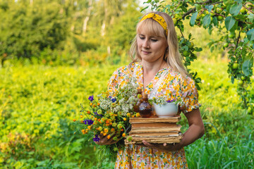 Woman with medicinal herbs in a meadow. Selective focus.