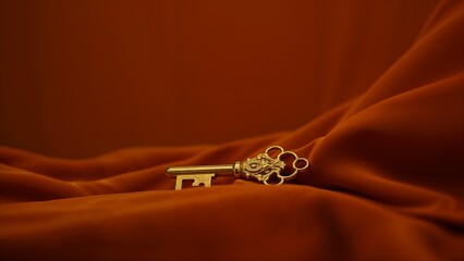 Vintage golden key resting on an elegant fabric, symbolizing wealth and opportunity, rich orange color scheme