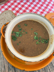 traditional goulash soup in typical orange enamel pot in Prague, Czechia.