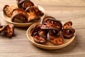 Dried Bael fruit on wooden plate, Herbal drink ingredient