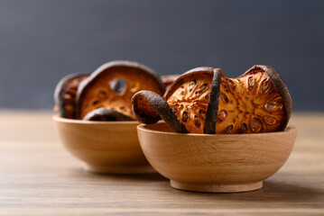 Dried Bael fruit in wooden bowl, Herbal drink ingredient