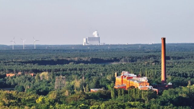 Telephoto drone video of the Knappenrode energy plant with the Schwarze Pumpe coal power station and wind turbines in the background. Drone move right.
