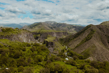 Fototapeta premium Exploring the lush green valleys and mountain ranges of Armenia under a cloudy sky