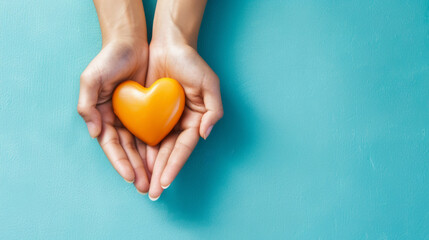 Hands holding an orange heart on a blue background as a symbol of volunteer appreciation and community support