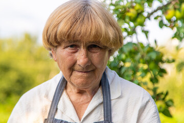 Portrait of an old woman in a garden. Selective focus.