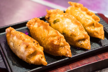 Crispy Golden Fried Dumplings Served on Elegant Black Plate - Authentic Asian Cuisine