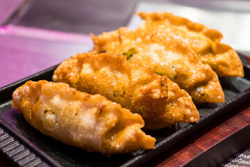 Crispy Golden Fried Dumplings Served on Elegant Black Plate - Authentic Asian Cuisine