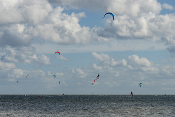 People swim on the sea on a kiteboard or kitesurfing. Kitesurfing lessons on the bay. Summer sport...