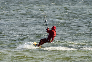 People swim on the sea on a kiteboard or kitesurfing. Kitesurfing lessons on the bay. Summer sport...