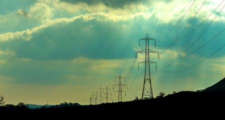 Electricity Pylons Tower Above And Stretch Across The Landscape Of The United Kingdom