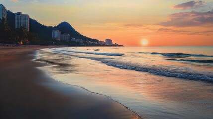The serene Hua Hin beach at dusk, with the sun setting