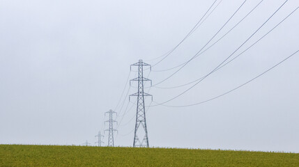 Electricity Pylons Tower Above And Stretch Across The Landscape Of The United Kingdom