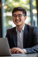 Man sits at a desk with a laptop, focused on his work