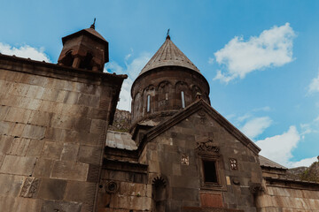 Obraz premium Explore the ancient architecture of Geghard Monastery in Armenia under a clear blue sky