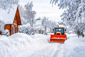 Snowplow clearing a residential road covered in deep snow after heavy snowfall
