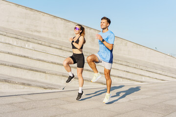 Two People Exercise Outdoors on a Sunny Day, Performing High Knees on Urban Steps in the Late...