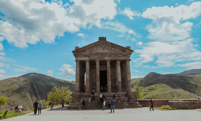 Visitors explore the ancient Garni Temple surrounded by stunning mountains in Armenia