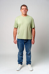 A man standing confidently in casual attire against a neutral background, showcasing a relaxed pose © fotofabrika