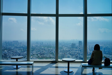 展望台から都市を眺める女性のシルエット