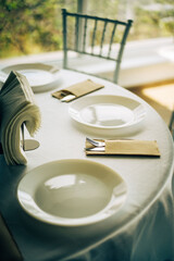 Restaurant table setting with white plate and cutlery
