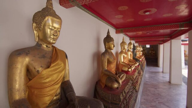 Serene row of golden Buddha statues in Wat Pho, Bangkok