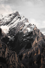 landscape of mountains with snow on the top, surrounded by forests with beautiful pine trees on...