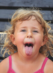 Child sticking out tongue. Selective focus.