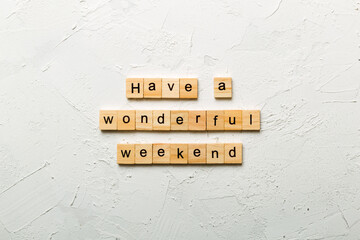 Have a wonderful weekend word written on wood block. Have a wonderful weekend text on cement table...