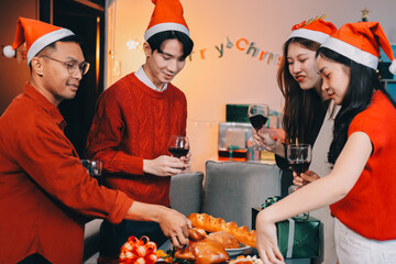 Group of young Asian man and women as friends having fun at a New Year's celebration, holding gift...