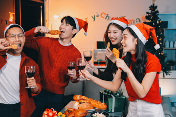 Group of young Asian man and women as friends having fun at a New Year's celebration, holding gift...